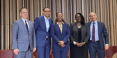 picture of school leaders and Dr. Michelle Walker-Davis on a stage