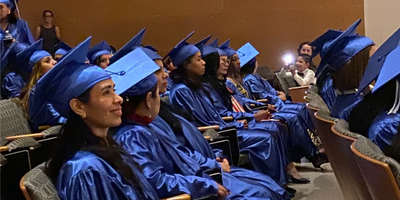 picture of rows of Briya PCS graduates in blue robes and hats
