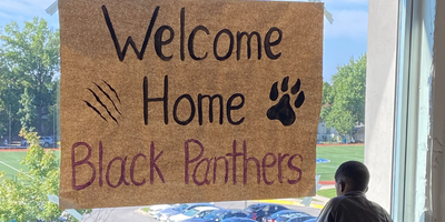 poster on a window that reads "Welcome Home Black Panthers"