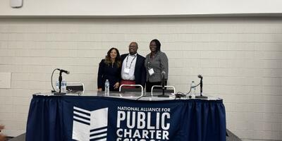 members of the DC PCSB Board behind a table labeled "National Alliance of Public Charter Schools"