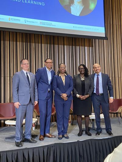 picture of school leaders and Dr. Michelle Walker-Davis on a stage