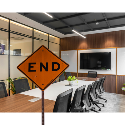 image of a board meeting room overlaid with a street sign that reads "End"