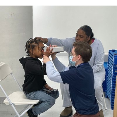 child getting their eyes tested at an eye health event