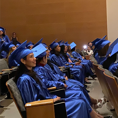 picture of rows of Briya PCS graduates in blue robes and hats