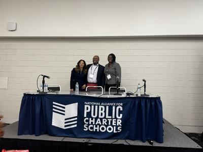 members of the DC PCSB Board behind a table labeled "National Alliance of Public Charter Schools"
