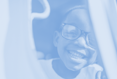 A child wearing glasses and smiling
