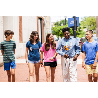 students from a DC public charter school walking down a sunny street sidewalk